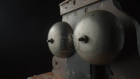 Photo for Wooden brown antique telephone apparatus with two metal hemispheres for signaling call, screwed on with screws. Old school bell. Retro phone mechanism for a loud chime. Vintage loud ting phone call on - Royalty Free Image
