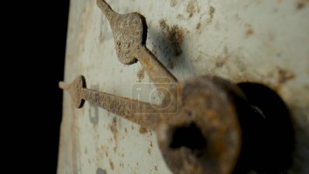 Foto de Old dial with rusty weathered hour and minute hands and numerals. White face of vintage clock with rust and dirt on black isolated studio background. Scratched dirty vintage clock. Part of a retro - Imagen libre de derechos