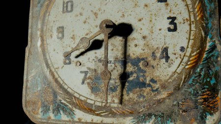 Téléchargez les photos : Old clock dial with rusty minute and hour hands covered corrosion. White face of vintage watch with weathered pattern, scuffs and scratches. Broken retro clock on a black isolated studio background - en image libre de droit