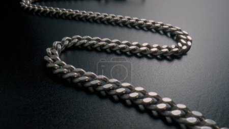 Photo for The silver chain lies on the gray surface of the table. Old retro bracelet with silvery links. Metal vintage pocket watch chain. Old bangle, necklace. Jewellery, bijouterie, expensive luxury jewelry - Royalty Free Image