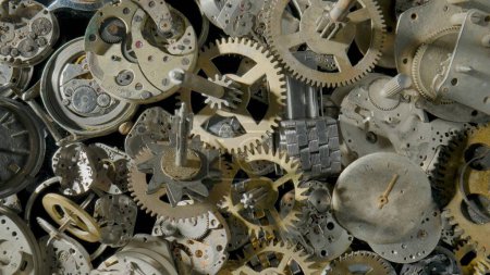 Photo for A pile of metal internal parts of an old clock. Dial, clockwork, bracelet, gears, cogwheels on black studio background. Disassembled clock mechanism of an old clock. Clock parts in the workshop - Royalty Free Image
