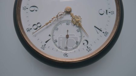 Téléchargez les photos : Antique pocket watch with a white dial and gold second, minute and hour hands on a light gray background. The face of an old clock with numbers close up. Round mechanical vintage pocket watch - en image libre de droit
