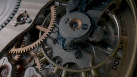 Photo for Antique pocket watch internal mechanism. Macro shot of clockwork of stopped clock with spring, gears, cogwheel and wheels with tootheds. Disassembled silver retro pocket watch inside. Clock workshop - Royalty Free Image