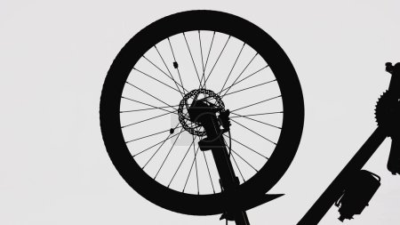 Photo for Black silhouette of a bicycle wheel on a white isolated background. Close up of round bike wheel with rubber tread tire, nipple, spokes, brake, bike frame and sports bottle. Part of a rubber wheel - Royalty Free Image