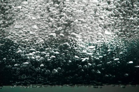 Téléchargez les photos : Beaucoup de bulles d'air brillantes s'échappant du tube de compresseur de paralon gris ou du filtre sous l'eau. Macro shot de l'équipement de travail pour l'aération de l'eau avec de l'oxygène dans l'aquarium. Bulles d'oxygène provenant de - en image libre de droit