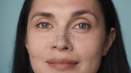 Photo for Beautiful eyes of a young woman. Close up of a womans face with clean, healthy skin on a blue background. Good vision and eye care. Contact lenses. Natural female beauty - Royalty Free Image