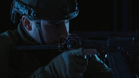 Téléchargez les photos : Un fusil d'assaut Kalachnikov entre les mains d'un soldat ukrainien. Portrait d'un soldat des forces armées ukrainiennes, examinant la portée d'un fusil. Gros plan d'un soldat armé d'un fusil - en image libre de droit