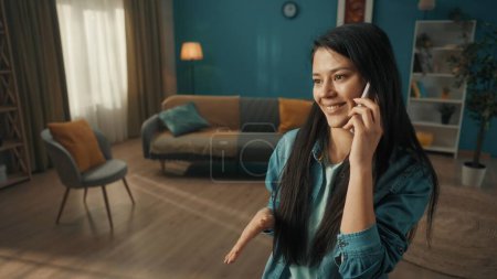 Photo for A young woman speaks on a smartphone, laughs. Portrait of an Asian woman with a phone to her ear close up - Royalty Free Image