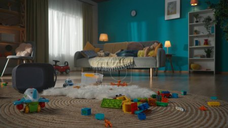 Photo for Calm family living room with nice modern furniture. The small child is sleeping on the couch with his teddy bear. Many colorful kids toys scattered on the floor. Daylight coming through the window. - Royalty Free Image