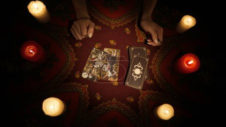 Photo for Fortune teller session scene. Close up shot of a female hands picking a few tarot cards from the deck, placing them on the table. Esoteric divination concept. - Royalty Free Image