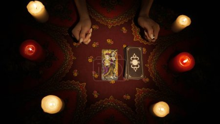 Photo for Fortune teller session scene. Close up shot of a woman hands picking one tarot card from the deck, placing it on the table. Esoteric divination concept. - Royalty Free Image
