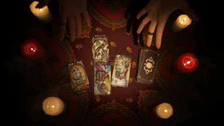 Photo for Fortune teller session scene. Close up shot of a female hands shows an open layout of tarot cards on the table made for client, images of cards are visible to the camera. Divination concept. - Royalty Free Image
