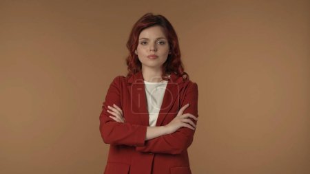 Photo for Medium isolated shot of a satisfied, relaxed and calm young woman crossing her arms on to demonstrate seriousness, strength and self-confidence. Business content or advertisement. - Royalty Free Image