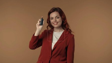 Photo for Medium isolated shot of an astonished, happy and active young woman holding a car key in her hand and looking at the viewer who may win or buy a car. Car seller, distributer, lottery advertisement. - Royalty Free Image