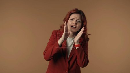 Photo for Medium isolated shot of a concerned young woman looking behind the camera and emotionally calling for somebody. Woman holds her hands next to her mouth. Creative content or advertisement. - Royalty Free Image