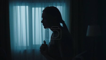 Photo for Crime scene creative concept. Closeup shot of young woman in the dark room, holding smartphone, looking scared. Portrait of female with phone. - Royalty Free Image