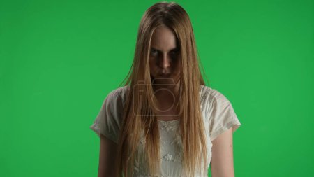 Photo for Medium green screen, chroma key shot of a posessed female, woman figure, ghost, poltergeist, zombie standing with her arms down, looking at the camera. Horror clip, advertisement, walking dead. Chroma - Royalty Free Image