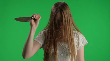 Photo for Medium green screen, chroma key shot of a posessed female, woman figure, ghost, poltergeist, zombie raising, pulling out a knife, looking at the camera. Horror clip, advertisement, walking dead - Royalty Free Image