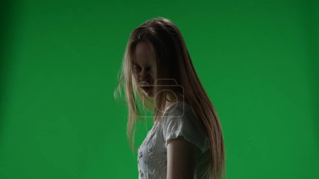 Téléchargez les photos : Ecran vert moyen, clef chromatique d'une femme possédée, silhouette de femme, fantôme, poltergeist, zombie tournant son visage vers la caméra avec un regard mort. Clip d'horreur, publicité, mort-vivant. Chroma - en image libre de droit