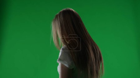 Téléchargez les photos : Écran vert demi-tour moyen, clef chromatique d'une figure féminine possédée, fantôme, poltergeist, zombie debout immobile avec la tête baissée. Les cheveux couvrent son visage. Horreur clip, publicité, mort - en image libre de droit