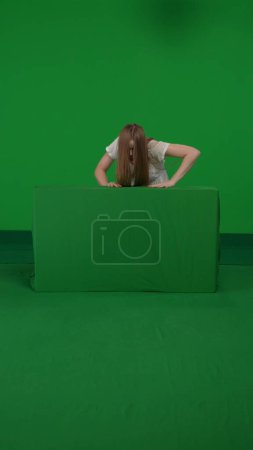 Photo for Full-size vertical green screen shot of a posessed female figure, ghost, poltergeist, zombie crawling over an obstacle towards the camera. The ring reference. Horror clip, advertisement, walking dead. - Royalty Free Image