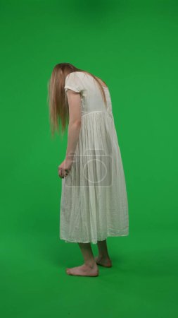 Photo for Full-size vertical green screen, chroma key shot of a posessed female, woman figure, ghost, poltergeist, zombie shot from behind. Ominious, hunched figure. Horror clip, advertisement, dead. - Royalty Free Image