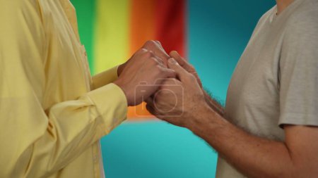 Téléchargez les photos : Gros plan, plan détaillé d'un couple homosexuel, transgenre, pansexuel, bisexuel, asexuel masculin ou non binaire debout devant l'autre, se tenant par la main. LGBT, égalité, contenu éducatif, fierté. - en image libre de droit
