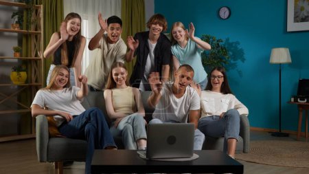 Photo for Full-size shot of a group of teens, young people gathered around a laptop to speak, talk with, have a video call with their friend, friends, waving hands, chatting. Advert, gen z, modern society. - Royalty Free Image