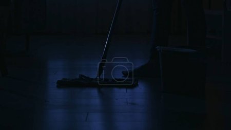 Photo for Closeup shot. Portrait of female silhouette in the dark apartment. Everyday life creative concept. Woman in the living room mopping the floor. - Royalty Free Image