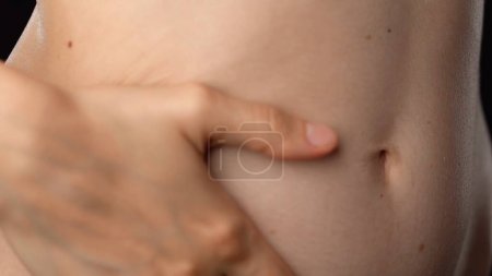 Photo for Skin texture and bodycare healthcare concept. Portrait of appealing young female model. Closeup studio shot of caucasian woman beautiful body part, touching tummy area smooth skin with hand. - Royalty Free Image