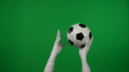 Photo for Detail green screen isolated chroma key photo capturing mummys hands raising a football, checked ball up in the air, throwing it. Mock up, workspace for your promotion clip or advertisement. - Royalty Free Image
