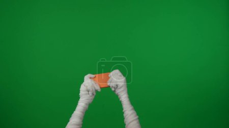 Photo for Detail green screen isolated chroma key photo capturing mummys hands holding a smartphone as if its playing a videogame. Mock up, workspace for your promotion clip or advertisement. - Royalty Free Image