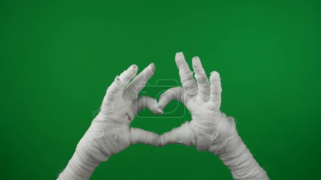 Foto de Detalle pantalla verde aislada croma clave foto captura momias manos levantadas en el aire, haciendo un corazón con sus dedos. Prepárate, espacio de trabajo para tu clip de promoción o anuncio. - Imagen libre de derechos