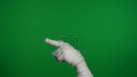 Foto de Detalle pantalla verde aislada croma clave foto captura momias mano apuntando con el dedo hacia el lado del marco, destacando algo. Prepárate, espacio de trabajo para tu clip de promoción o anuncio. - Imagen libre de derechos
