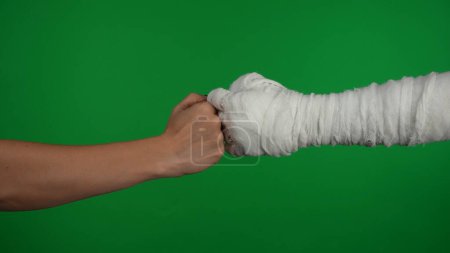 Photo for Detail green screen isolated chroma key photo capturing the mummys hand reaching for the human hand, friendly bumping the fists. Mock up, workspace for your promotion clip or advertisement. - Royalty Free Image