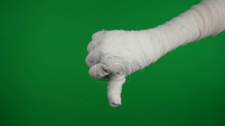 Photo for Detail green screen isolated chroma key photo capturing mummys hand giving a thumbs down in sign of dislike. Mock up, workspace for your promotion clip or advertisement. - Royalty Free Image