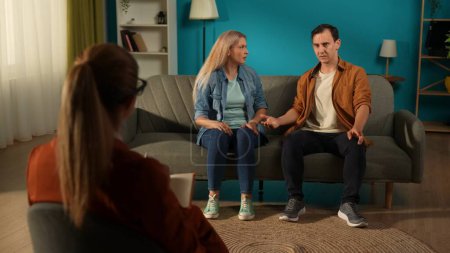 A couple at a psychotherapy session solving their problems. Back view of a female psychologist giving advice to the couple sitting in front of her