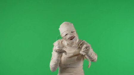 Photo for Green screen isolated chroma key photo capturing a mummy jumping at the camera to scare, booing and roaring, pulling hands towards the camera. Mock up for your promotion clip or advertisement. - Royalty Free Image