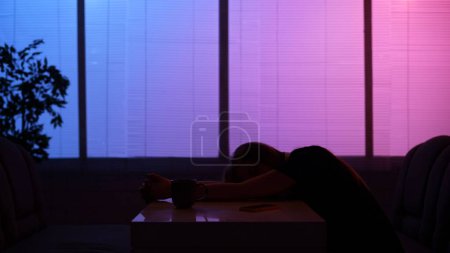 Photo for Everyday life and people relationships concept. Portrait of person in cafeteria. Silhouette of man sitting at the fast food bistro bar at night, napping at the table, sleeping after long working day. - Royalty Free Image