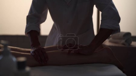 Foto de Un tiro medio. Masajista, especialista en masajes dando un masaje a su paciente. Siluetas de una mujer y un hombre en la sala de masajes, procedimiento de spa. Atención médica, tratamiento médico, terapia holística. - Imagen libre de derechos