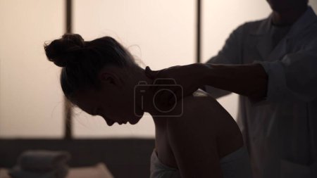 Téléchargez les photos : Masseur, spécialiste du massage redonnant massage à son patient. Silhouettes d'une femme et d'un homme dans la salle de massage, procédure spa. Soins de santé, traitement médical, thérapie holistique. - en image libre de droit