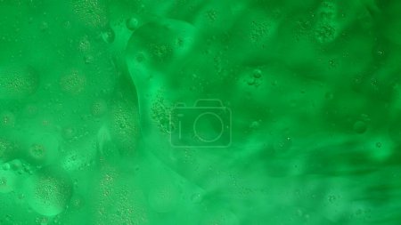 Photo for Water and liquids creative abstract advertisement concept. Close up shot of surface texture. Liquid shiny oil flows on beautiful green colored water surface, abstract background, wallpaper template. - Royalty Free Image