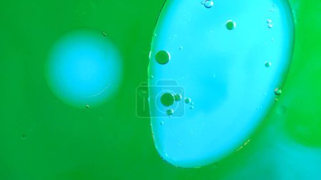 Photo for Water and different liquid creative advertisement concept. Close up studio shot of aqua texture. Green colored water surface with clear oil droplets mixing together, abstract wallpaper background. - Royalty Free Image