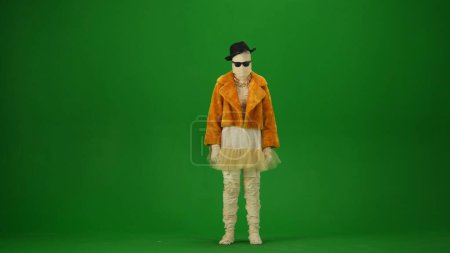 Photo for Glamorous mummy in an orange fur coat, hat and sunglasses. Green screen isolated chroma key. Mock up, workspace, advertisement. Full length. Halloween holidays. - Royalty Free Image