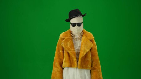 Photo for Glamorous mummy in an orange fur coat, hat and sunglasses. Green screen isolated chroma key. Mock up, workspace, advertisement. Medium size.Halloween holidays. - Royalty Free Image