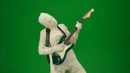 Photo for Green screen isolated chroma key photo capturing a mummy playing guitar and dancing to the music. Halloween holidays. Mock up for your promotion clip or advertisement. Medium size - Royalty Free Image
