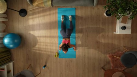 Téléchargez les photos : Vue de dessus capturant une jeune femme faisant son exercice de yoga matinal, s'étirant devant la fenêtre. Maison, chambre, activités intérieures. Mode de vie sain et actif, routine matinale, atteindre les objectifs. - en image libre de droit