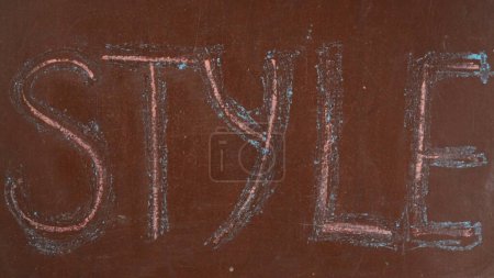 Photo for Textured brown chalkboard background. Style is written on the board with two colorful pieces of chalk. Close up shot. Educational and creative content, fashion concept. - Royalty Free Image