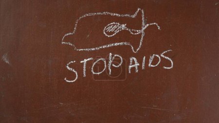 Photo for Textured chalkboard background. A condom with a sperm inside is drawn on the board, stop aid is written below with a piece of chalk. Close up . Educational and creative content, sexual education. - Royalty Free Image