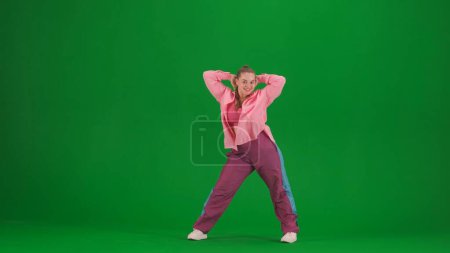 Foto de Atractiva mujer bailando jazz-funk en pantalla verde croma fondo clave en un estudio. Coreografía de danza moderna dinámica y enérgica. Longitud total. Contenido creativo, clip promocional o publicidad. - Imagen libre de derechos